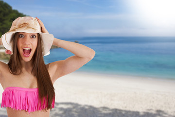 young woman on the beach in the summer with expression of surprise