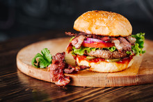 Burger With Bacon, Meat, Tomato And Lettuce   On Wooden Background. Close Up