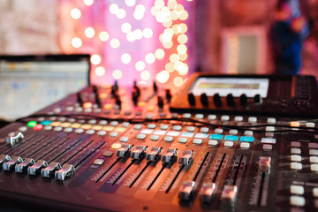 od adjusters and red buttons of a mixing console. It is used for audio signals modifications to achieve the desired output. Applied in recording studios, broadcasting, television.