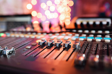 od adjusters and red buttons of a mixing console. It is used for audio signals modifications to achieve the desired output. Applied in recording studios, broadcasting, television.