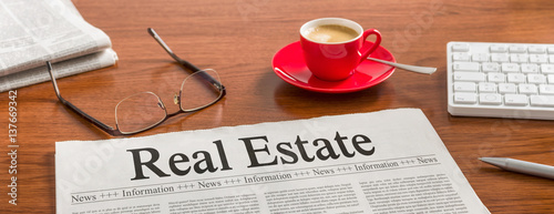 Cuadros en Lienzo A newspaper on a wooden desk - Real Estate