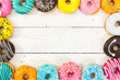 Colorful donuts on light wooden background