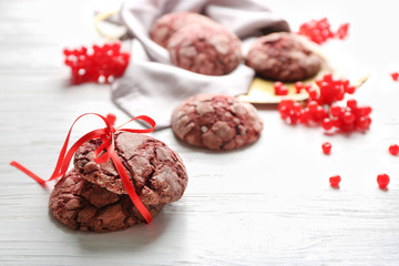 Wall Mural - Delicious chocolate cookies and viburnum on white wooden table, closeup