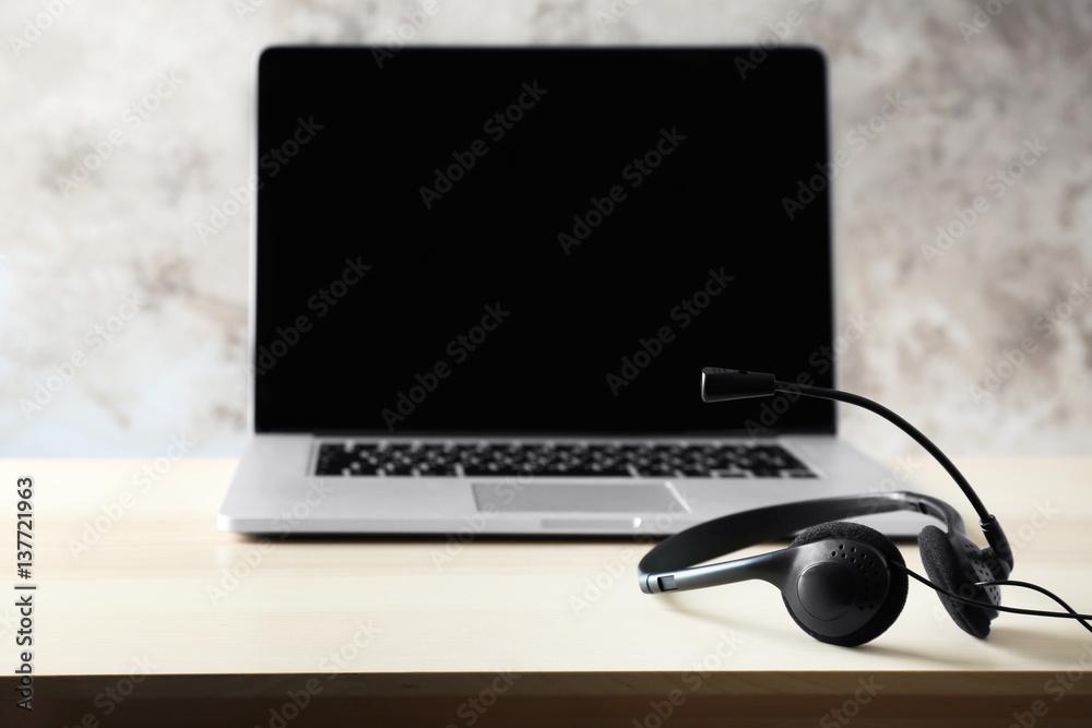 Modern laptop and headphones on table