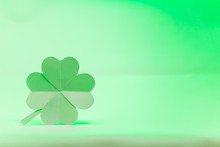 Hand Made A Paper Four-leaf Clover On Soft Green Light Background.