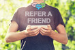 Refer A Friend concept with young man holding his smartphone