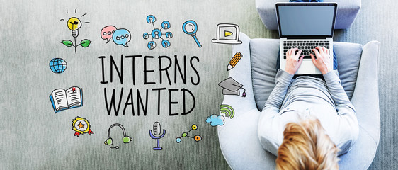 Wall Mural - interns wanted text with man using a laptop
