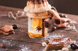 Hot orange punch with baklava on wood closeup. Warm tea glass with citrus and spices in knitted cover with sweets on wooden table. Dessert, rustic treat, winter detox concept