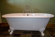 © Madele - Old type modern replica of a white footed bath tub in olive green bathroom