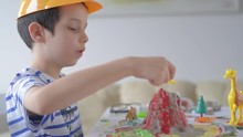 Boy Experimenting With Clay Volcano.The Boy Is A Creative Game With Volcanoes
