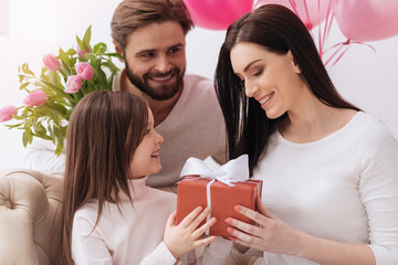 Cheerful positive girl giving a present