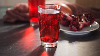 Ripe pomegranates with juice on a gray stone table