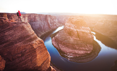 Wall Mural - hiker overlooking horseshoe bend at sunset, arizona, usa