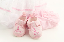 Pink Baby Booties On A Bright Pink Background. Baby Clothing
