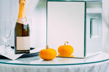 wedding ceremony decorated outside with pumpkin , candles and glass