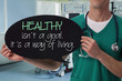 © dream@do - Male doctor holding health inspiration motivation quote on blackboard.