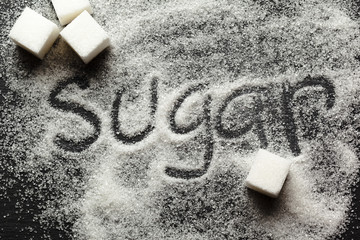 The word sugar written into a pile of white granulated sugar