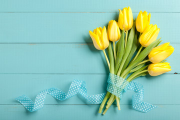 Yellow tulips on blue wooden background