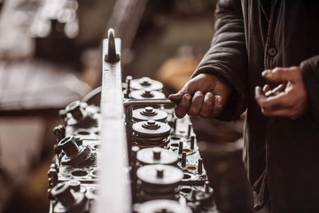 Working hand in the engine oil with the tools