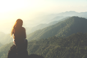 silhouette woman sitting on mountain in morning and vintage filter