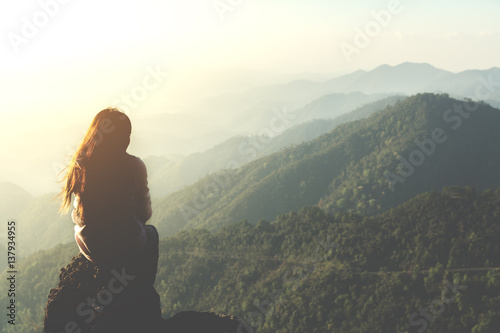 silhouette woman sitting on mountain in morning and vintage filter Poster