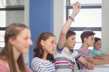 Wall Mural - Student raising hand in classroom