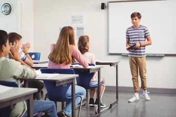 schoolboy giving presentation in classroom