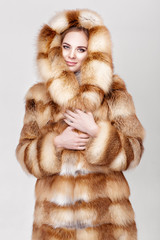 Wall Mural - portrait of beautiful young blonde woman in luxury Fox fur coat.