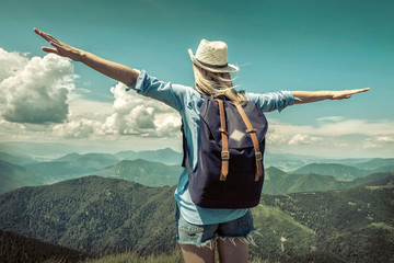 Wall Mural - Woman hiking in mountains at sunny day time.