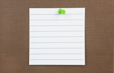 Wall Mural - Blank ruled note paper attached to brown fabric wall with green push pin. Copy space.
