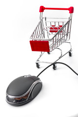 Online shopping and ecommerce concept with a optical mouse with cord and a shopping cart isolated on white background