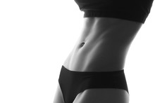 Sexy slim fit woman body abs. Muscled abdomen. Sportswear. Isolated on white. Black and white image