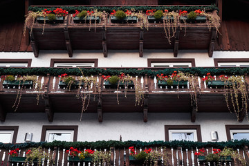 Wall Mural - Looking up at chalet balconies with flowers in Alps