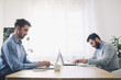 © Cavan Images - Businessmen working at table in office