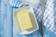 butter on butter dish on blue wooden surface