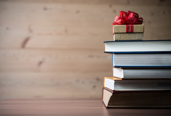 Gift box and book on wooden table. For love or valentine day concept