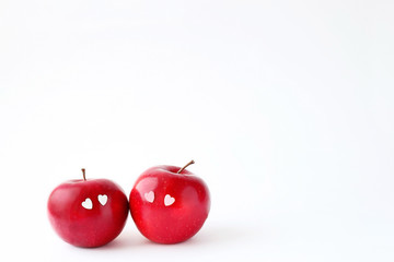 Two lovely red apples with hearts eyes on white background. delicious fresh fruit apple. symbol of love, Valentine's day. minimal style. element for design. copy space