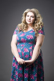 Young beautiful happy blonde plus size model in dres, xxl woman portrait on gray  studio background Stock Photo