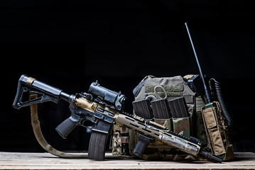 Helmet,rifle and military flak jacket/Assault rifle with sight,bulletproof vest,ammo and radio on dark background