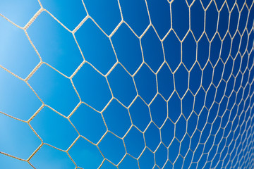 white soccer or football goal net against clear deep blue sky