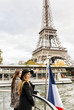 © Westend61 - Paris, France, two tourists taking a cruise on Seine River with Eiffel Tower in the background