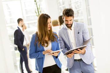 Wall Mural - Young couple discussing about business in a modern office