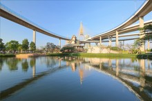 Lakeside Scenery Under Bhumibol Bridge (or Industrial Ring Road ) With View Of Elevated Highway Interchange & Bridge Tower Reflecting On Smooth Lake Water In Lat Pho Urban Park, Bangkok City, Thailand