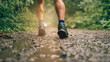 © AYAimages - Muscular calves of fit male jogger training for cross country forest trail race in the rain on a nature trail.