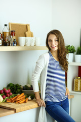 Young woman standing near desk in the kitchen