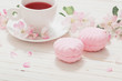 Red tea with flowers on white wooden background