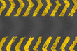 Grunge distressed yellow road marking paintbrush stroke stripes on dark background
