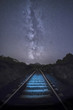 Stunning view of the milky way with a illuminated railroad in the foreground, Sardinia, Italy.