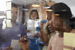 © Monkey Business - Businesswoman Writing Ideas On Glass Screen During Meeting