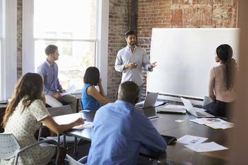 Businessman At Whiteboard In Brainstorming Meeting